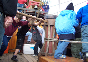 The student crew put all their weight into the capstan bars.
