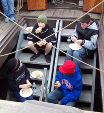 Kris, David, Nate, and Zach eat their lunch on the stairs.