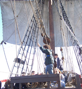 The foremast crew works the fore course.