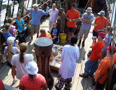 Dr. Philips leads the new crew members though an introductory briefing on the weather deck.