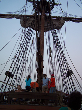 The foremast crew douses the fore course.