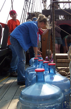 Students line up empty water bottles on the weather deck.