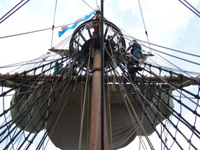 Several crew members work in the main mast top.