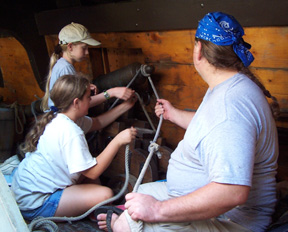 Kathleen and Ericka help Mr. Prime batten down a cannon.