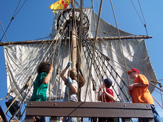 The foremast crew observes their work as they adjust the fore top.