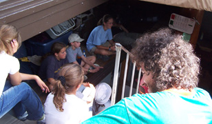 Student crew members gather on the orlop deck for a meeting.