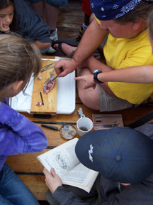 With student assistance, Mr. Prime dissects a fish on the weather deck.