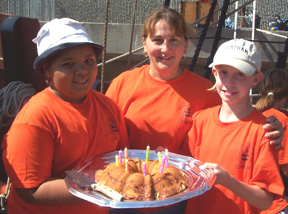 Madena, Mrs. Fountain, and Kathleen gather around their birthday cake.