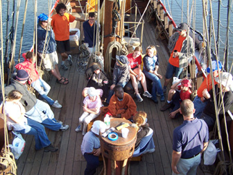 The crew gathers around the weather deck while Captain Reynolds preps them on what to expect.