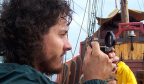 Mr. Colley scans the horizon with a hand-bearing compass.
