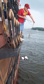 Standing on the port channel, Keith swings a secchi disk down into the water.