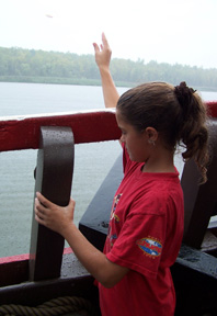 Shannon tosses a wooden biscuit into the water to test the current speed.