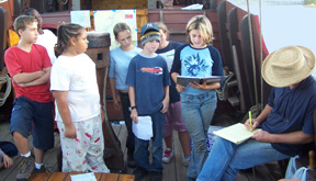 Captain Reynolds jots down a few notes after questioning the port watch on their presentation.