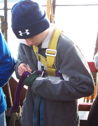 Nate buckles himself into a safety harness.
