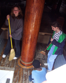 Ginny, Emily, and Jamar help each other sweep the orlop.