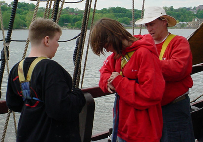 Mr. Weisse shows Bryan and Sam how to use a safety harness.