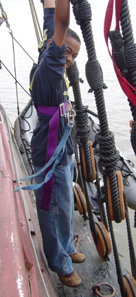 Jamal hangs from the rigging, his feet a few inches from the channel.