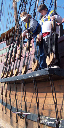 Ms. Farrell shows Daymien how to lower a Secchi dish into the water.