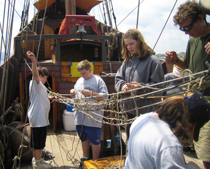 Captain Berg and several students make a hammock from assorted lengths of rope.