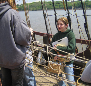 Kiera, who is bring lunch supplies up from the galley, looks displeased when she discovers a partially-constructed hammock blocking her path.