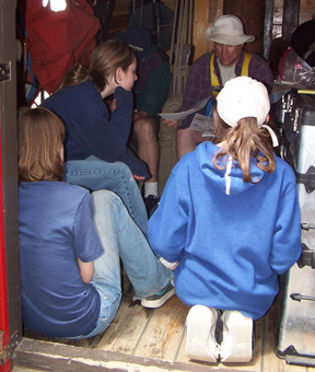 Mr. Weisse proposes a found poem project to Kiera, Sam, and Emily in the forecastle. (Ginny is hidden behind Emily.)
