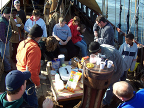 The crew gathers around the capstan for cereal and bagels.
