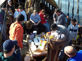The crew gathers around the capstan for cereal and bagels. 