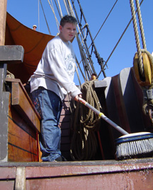 Bryan scrubs the quarter deck.