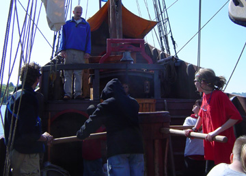 Students turn the capstan to raise the anchor.
