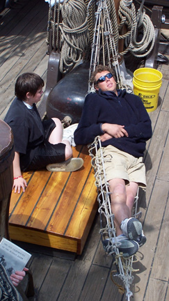 Captain Berg stretches out on the new hammock while Daymien stands by.