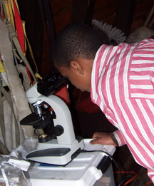 Jamal studies a sample under the microscope.