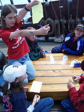 Sami proudly shows off her solution while Andi, Veronica, Daymien, and Emily look on.