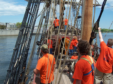 The crew looks on as the Half Moon comes into port, with the water cannons growing nearer.