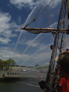 Water cannons arc over the approaching ship.
