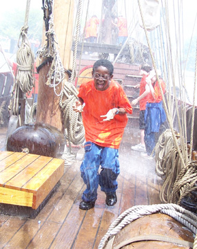 Jamal breaks for cover as the water cannons produce a sudden downpour on the weatherdeck.