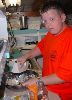 Bryan whips up cookie batter in the galley.