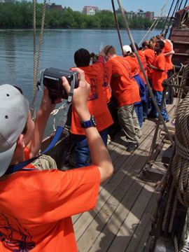 Dylan snaps a photo as his crewmates hang off the rail, watching Albany come into view.