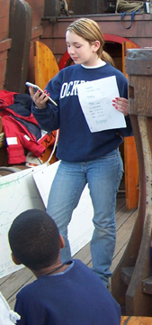 Kiera checks her notes while delivering her report.