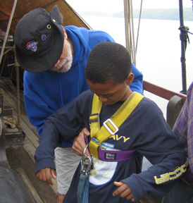 Captain Washington checks the fit of Jamal's safety harness.