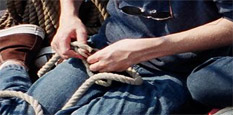 Closeup of a student's hands tying a knot.