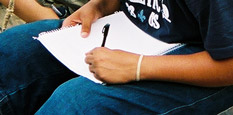 Closeup of a student's hands writing notes.