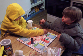 Nick and Tyler play a board game in the galley.
