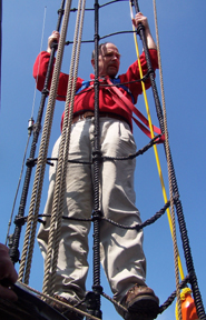 Captain Reynolds in the shrouds to demonstrate proper harness and climbing techniques.
