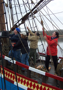 The fore mast crew hauls on lines to raise the top yard.