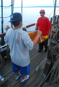 Gabriel and Carlos fold the Lion Rampant flag.