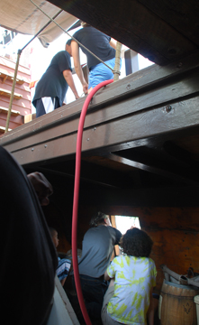 Senior crew members close a gun port.