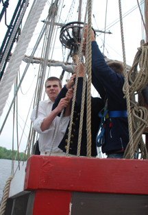 Reenactor crew members heave on the anchor tackle.