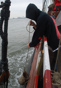 Muhammad and Thwe-Thwe use a canvas bucket to collect a water sample.