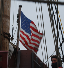 High winds whip the American flag flying on the Half Moon's jackstaff.