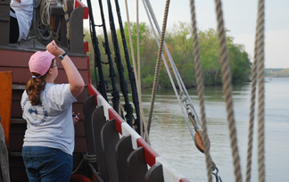 Casey throws a wood chip overboard.
